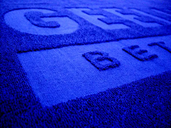Blauwe handdoek met een logo in reliëf geweven Blauwe handdoek met een logo in reliëf geweven